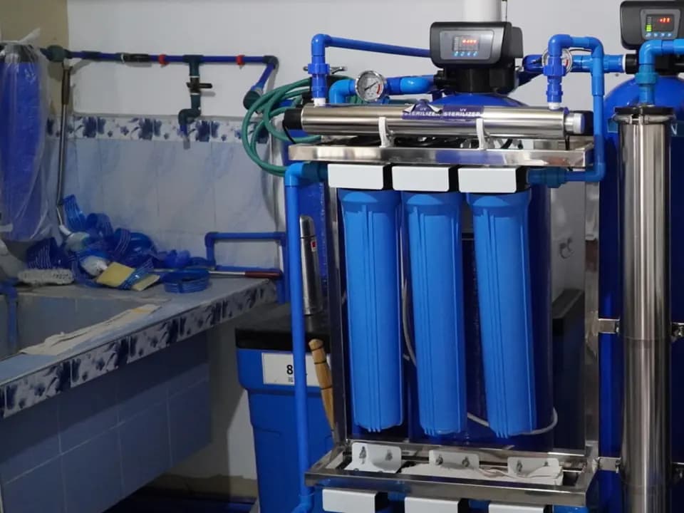 Tabung filter biru dan sterilizer UV di depot air minum isi ulang